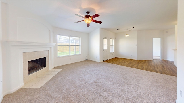 unfurnished living room with visible vents, baseboards, a fireplace, a ceiling fan, and carpet floors