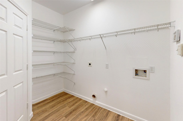 washroom with hookup for an electric dryer, hookup for a washing machine, baseboards, light wood finished floors, and laundry area