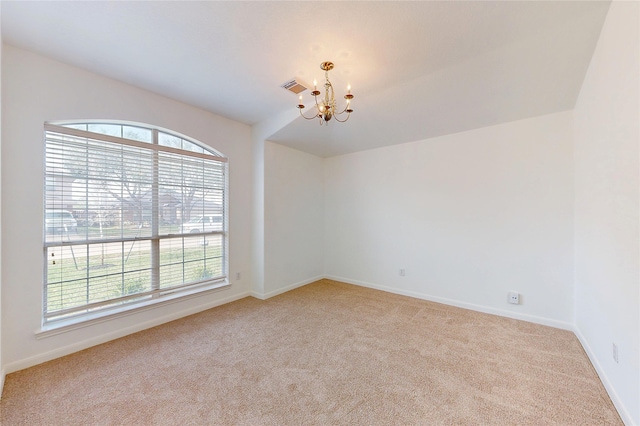 spare room featuring light colored carpet, visible vents, baseboards, and an inviting chandelier