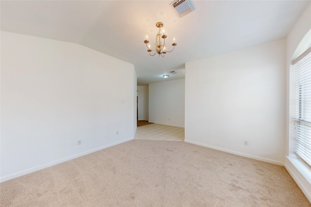 empty room featuring light colored carpet, a notable chandelier, visible vents, and baseboards