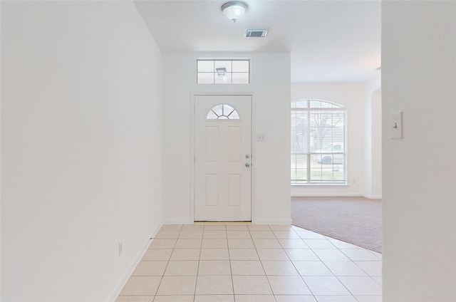 entrance foyer featuring light tile patterned flooring, light carpet, baseboards, and visible vents