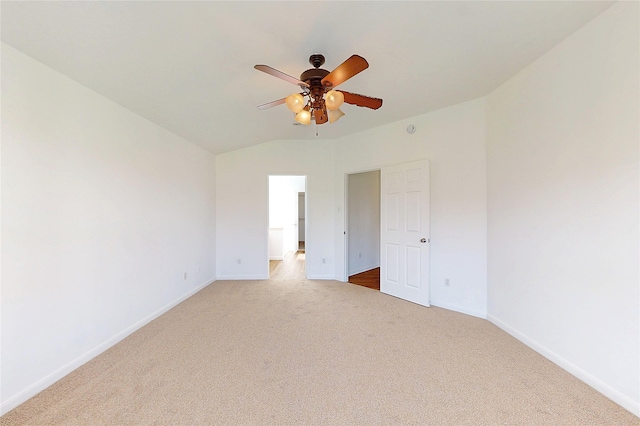 empty room with baseboards, vaulted ceiling, ceiling fan, and carpet flooring