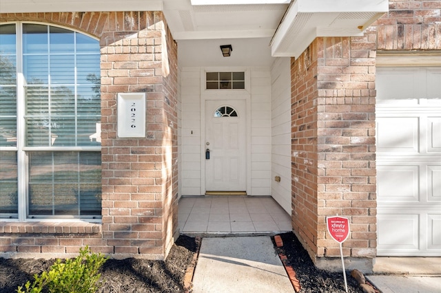 doorway to property featuring brick siding