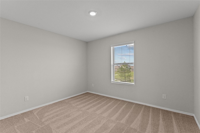 carpeted spare room featuring baseboards