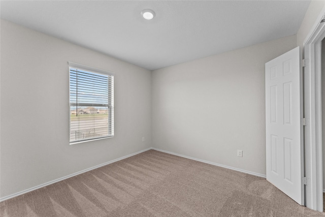 carpeted spare room with baseboards