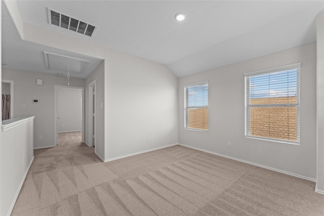 empty room featuring baseboards, visible vents, light carpet, and attic access