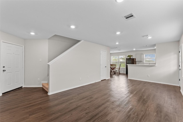 unfurnished living room featuring visible vents, dark wood-type flooring, baseboards, stairs, and recessed lighting