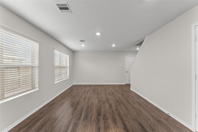 empty room featuring recessed lighting, visible vents, baseboards, and dark wood finished floors