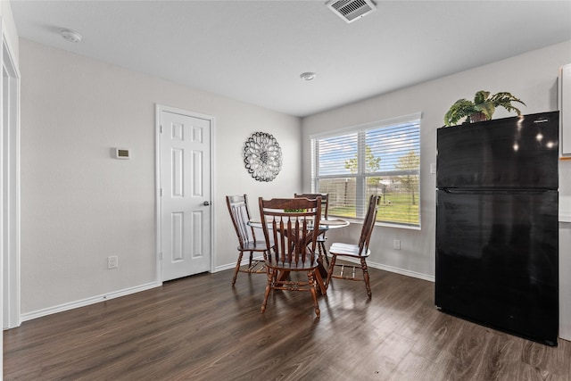 dining room with wood finished floors, visible vents, and baseboards