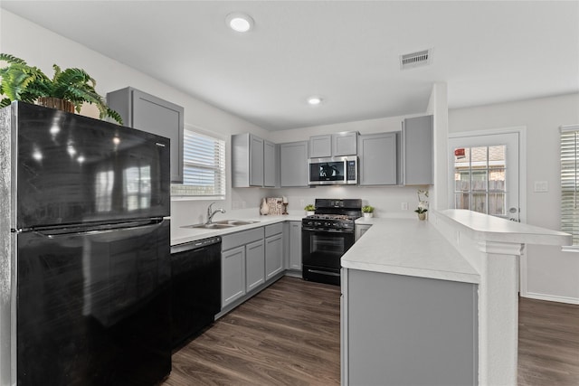 kitchen featuring visible vents, gray cabinets, black appliances, and a sink