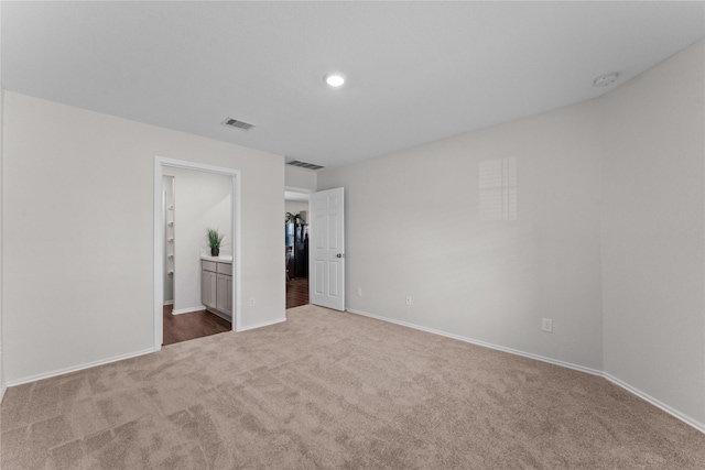 unfurnished bedroom featuring recessed lighting, carpet flooring, baseboards, and visible vents