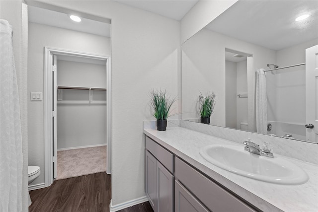 bathroom with baseboards, toilet, a shower with curtain, wood finished floors, and vanity