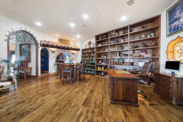 office with visible vents, recessed lighting, arched walkways, and hardwood / wood-style flooring