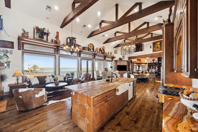 kitchen with open floor plan, a notable chandelier, visible vents, and beamed ceiling