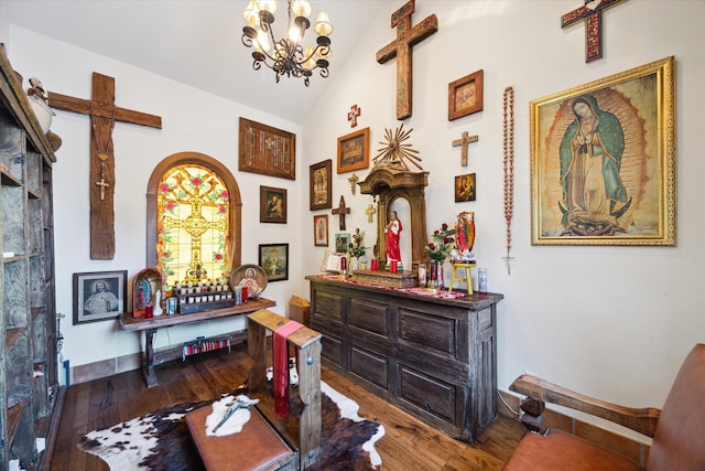 hallway featuring a chandelier, baseboards, vaulted ceiling, and hardwood / wood-style floors