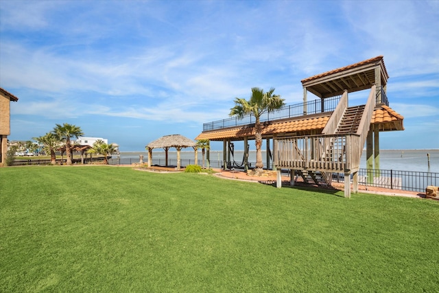 view of yard with a gazebo, fence, stairway, and a water view