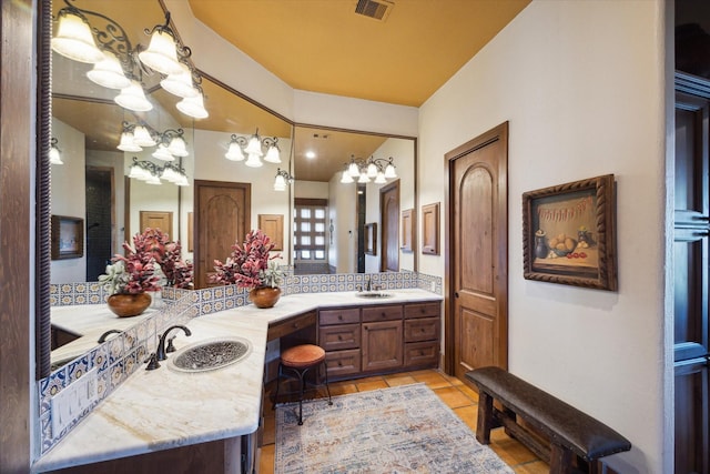 bathroom featuring tile patterned floors, visible vents, a sink, and an inviting chandelier