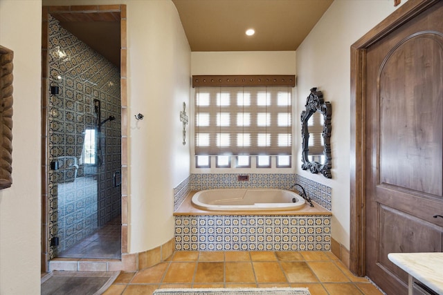 bathroom with a shower stall, tile patterned flooring, and a garden tub