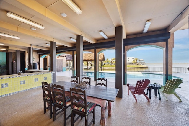 carpeted dining space featuring beam ceiling