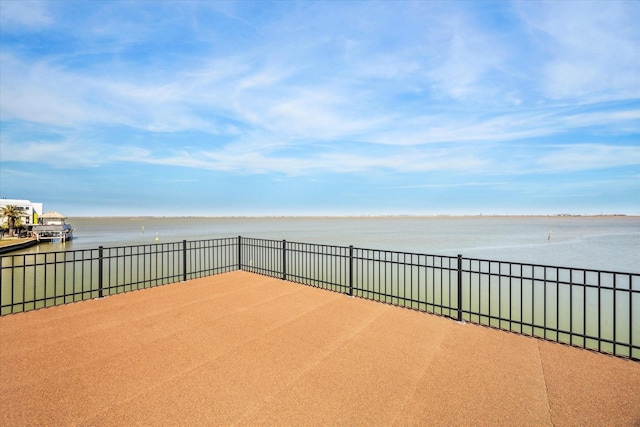 view of patio with a water view and fence