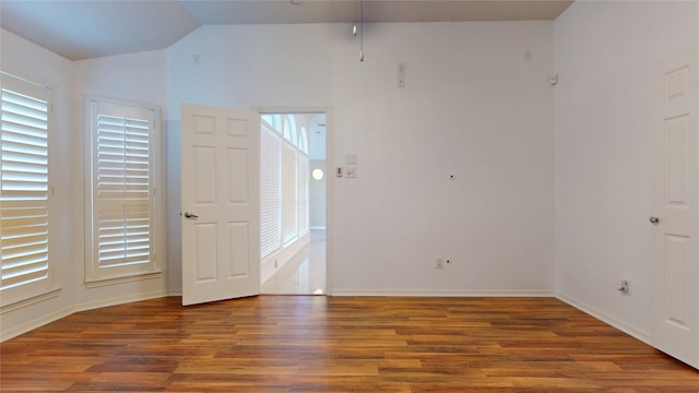 spare room with lofted ceiling, wood finished floors, and baseboards