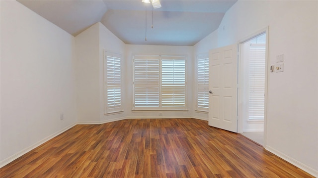 unfurnished room featuring vaulted ceiling, baseboards, and wood finished floors