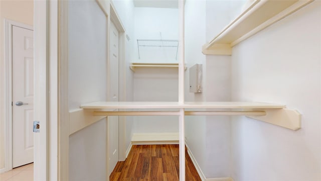 walk in closet with wood finished floors