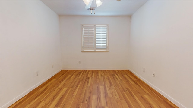 unfurnished room with light wood-style flooring, a ceiling fan, and baseboards