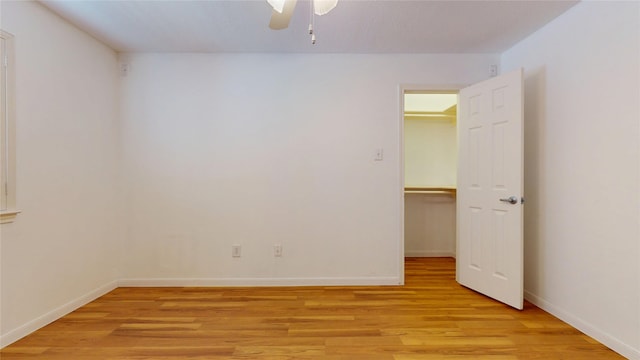 empty room with light wood-style flooring, baseboards, and a ceiling fan