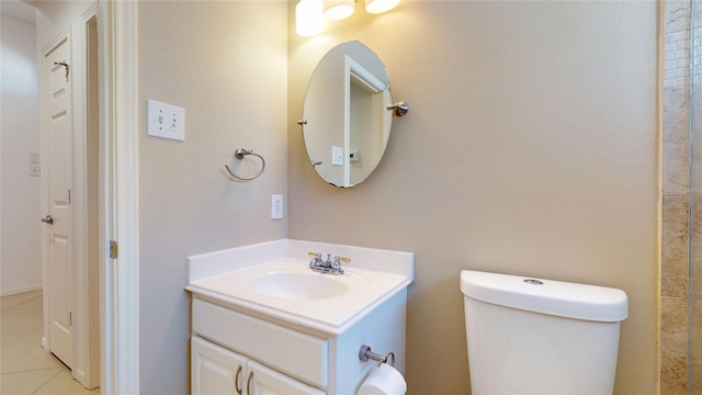 bathroom with toilet, vanity, and tile patterned flooring