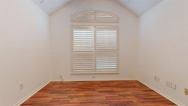 unfurnished room with baseboards, lofted ceiling, and wood finished floors