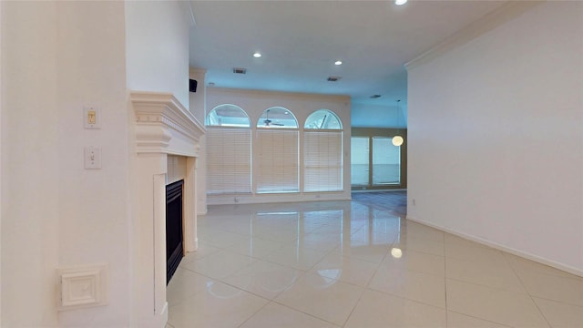 unfurnished living room with visible vents, baseboards, light tile patterned flooring, recessed lighting, and a fireplace