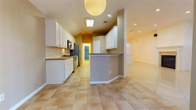 kitchen featuring open floor plan, tasteful backsplash, appliances with stainless steel finishes, and white cabinets