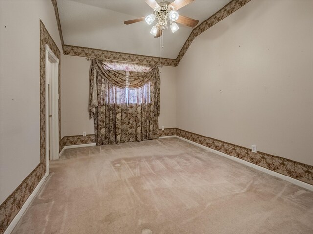 empty room featuring baseboards, carpet flooring, a ceiling fan, and vaulted ceiling