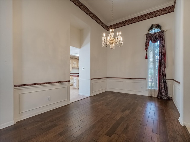 2402 Duhon Pl, Seabrook, TX 77586 - unfurnished dining area featuring a chandelier, crown molding, dark wood-style floors, wainscoting, and a decorative wall