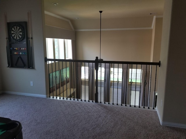 empty room featuring carpet, crown molding, vaulted ceiling, and baseboards