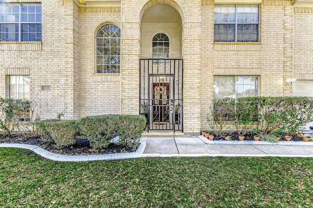 doorway to property featuring brick siding