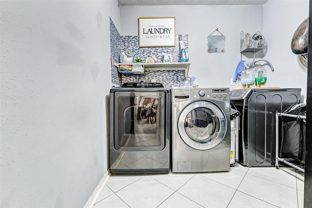 laundry area with laundry area, independent washer and dryer, and tile patterned floors