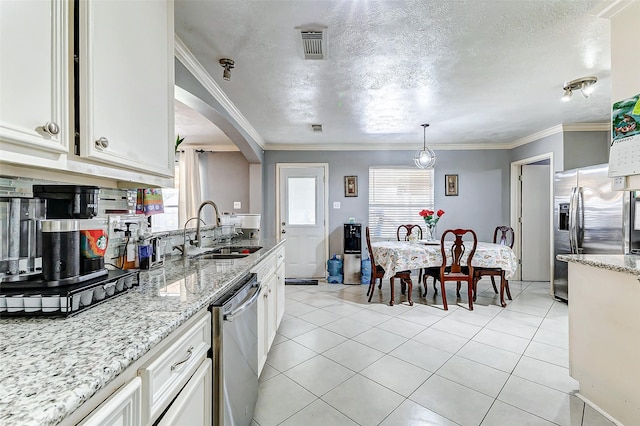 kitchen with visible vents, a sink, appliances with stainless steel finishes, white cabinets, and light tile patterned floors