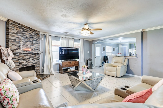 living area featuring a textured ceiling, light tile patterned floors, visible vents, and ceiling fan