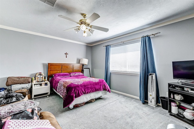 carpeted bedroom with visible vents, a textured ceiling, ornamental molding, and a ceiling fan