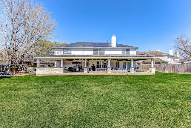 back of property featuring a playground, a yard, a patio area, and a chimney