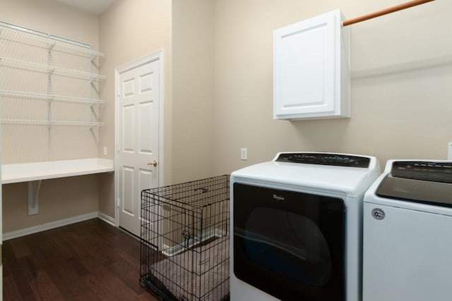 clothes washing area featuring dark wood-style flooring, cabinet space, baseboards, and separate washer and dryer