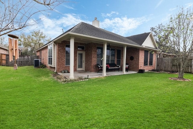 rear view of house with a patio, brick siding, central AC unit, and a fenced backyard