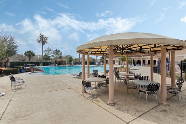 pool with a gazebo, fence, and a patio area