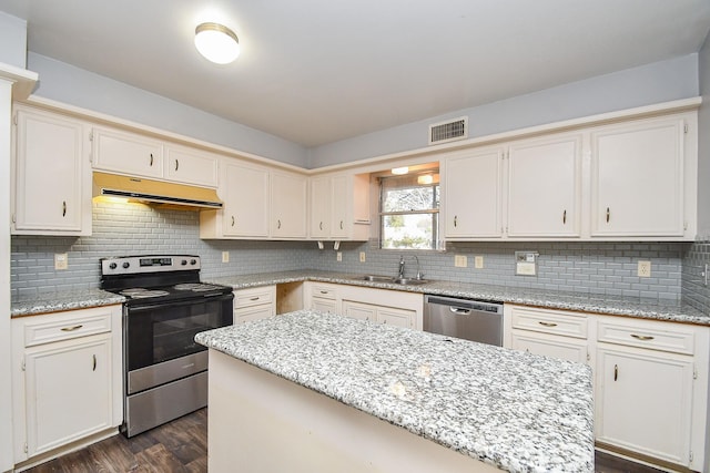 kitchen with visible vents, under cabinet range hood, a sink, dark wood finished floors, and appliances with stainless steel finishes