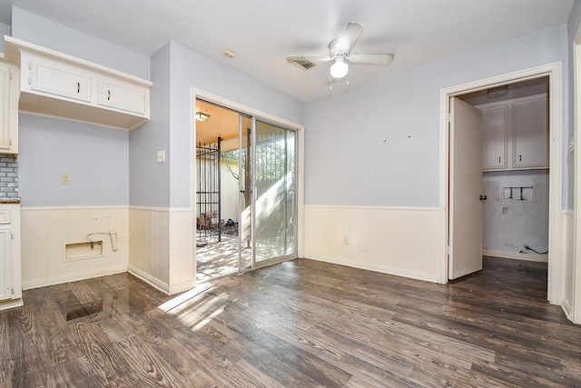 unfurnished dining area with visible vents, a ceiling fan, dark wood-style flooring, and wainscoting