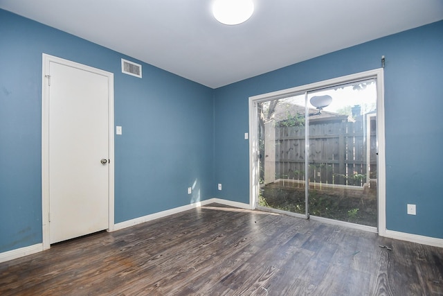 unfurnished room with visible vents, baseboards, and wood finished floors