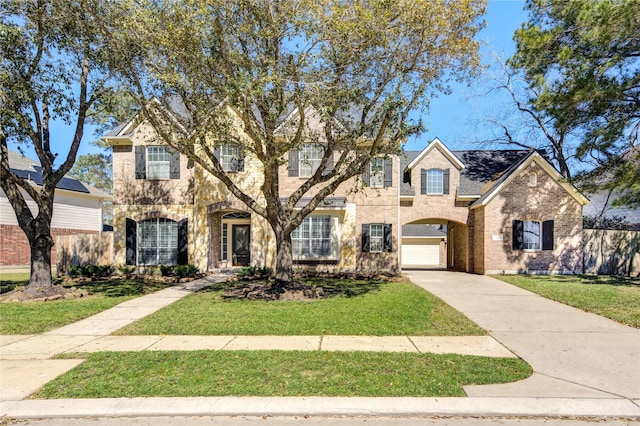 view of front of home with a garage, brick siding, concrete driveway, and a front lawn