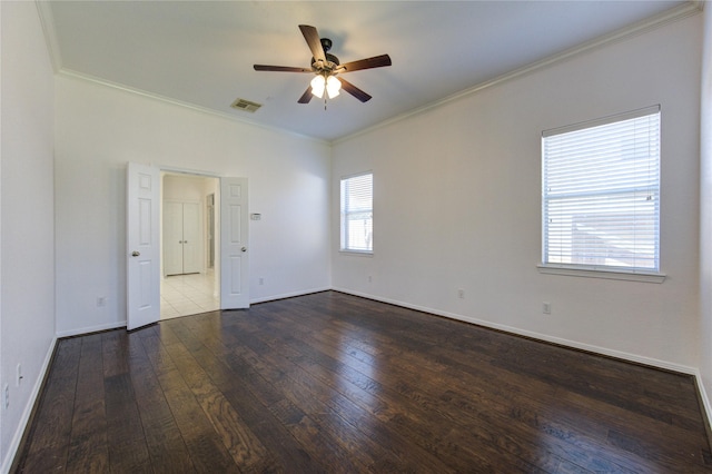 unfurnished room with dark wood-type flooring, a ceiling fan, visible vents, and ornamental molding